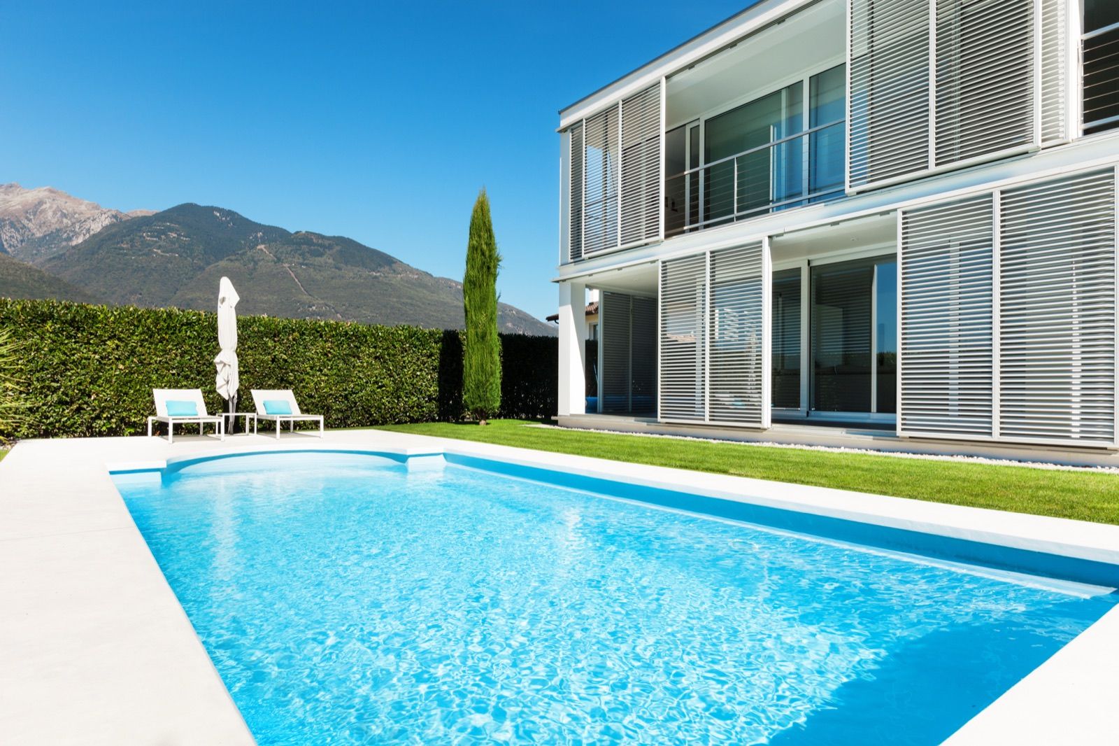 Backyard pool with mountains behind a modern home