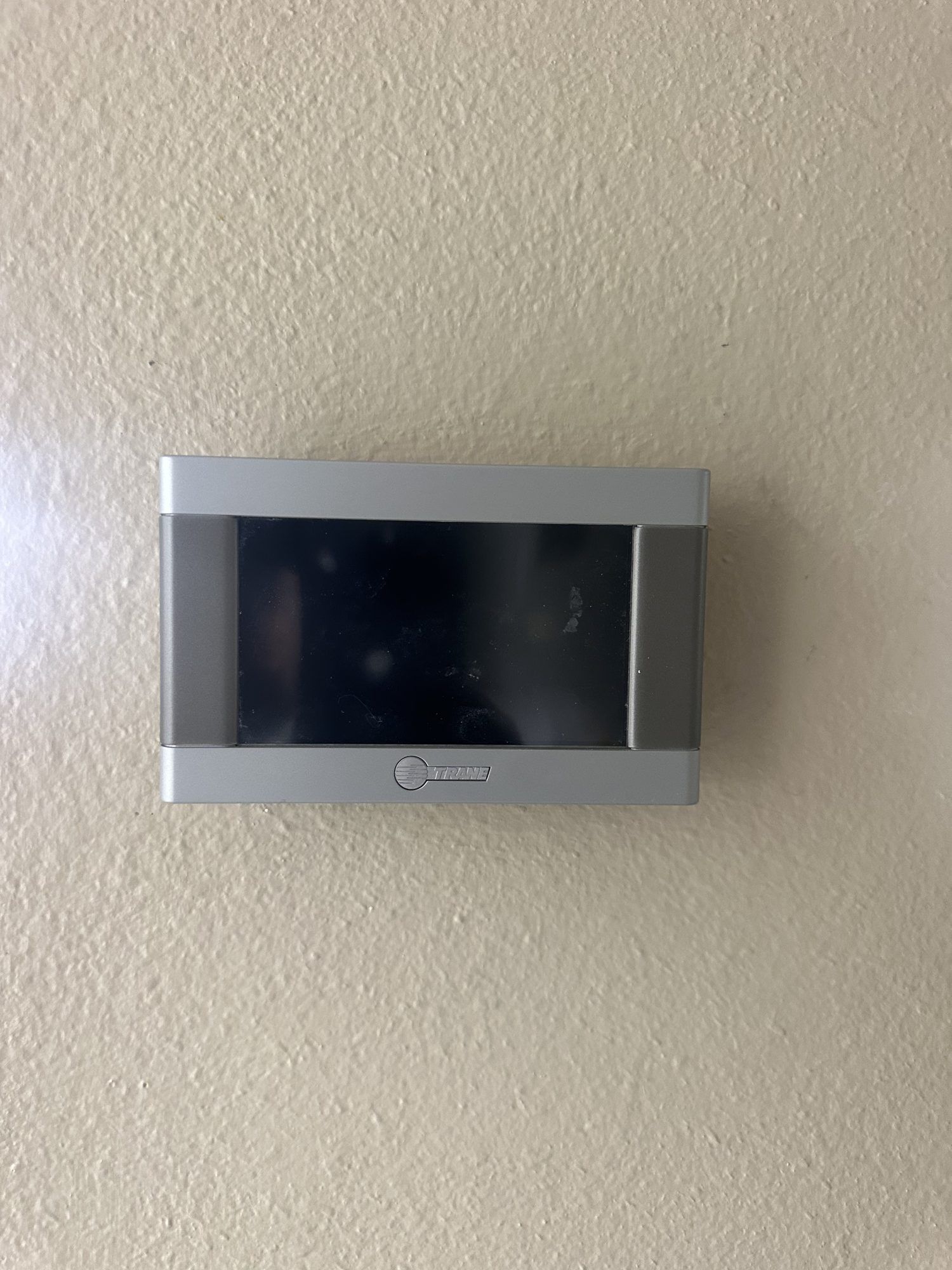 Trane touchscreen thermostat installed on a wall